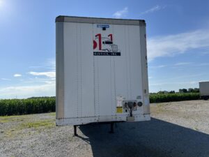 A large white trailer parked on the side of a road.