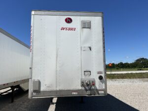 A white trailer with red lettering on the side.