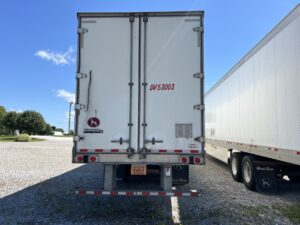 A white truck parked in the middle of a parking lot.