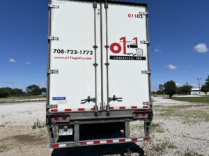 A white truck parked on top of a field.