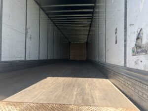 A large long trailer with a wooden floor.